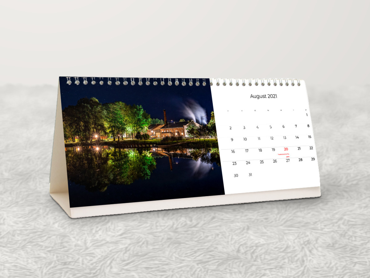 Lauakalender öise vabrikufotoga valgel karvasel vaibal