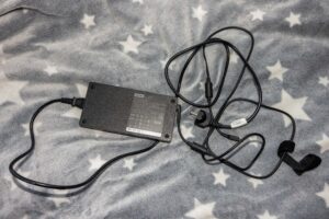Lenovo laptop power adapter with tangled cords on a gray star-pattern blanket